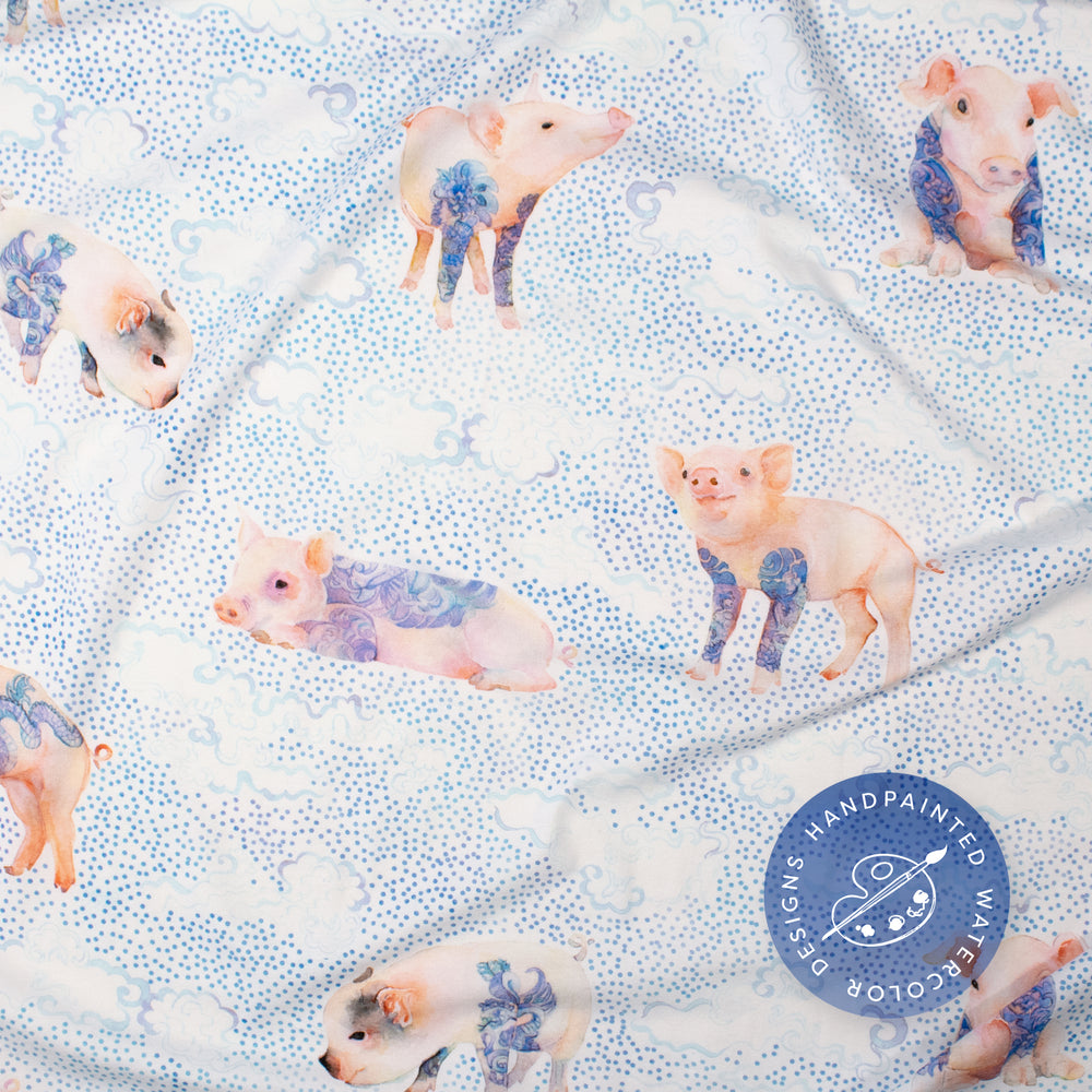 
                      
                        Closeup for detail, Pima cotton blanket with japanese inspired watercolor artwork showing a variety of tattooed pigs, on a background of tiny dots and clouds.
                      
                    